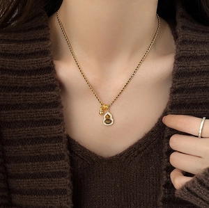 Close-up of 18K gold plated gourd pendant necklace with tiger eye stone and rhinestones