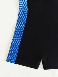 Detailed close-up of gradient blue scale pattern on black athletic one-piece swimsuit