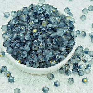 Close-up of matte blue-grey glass beads with gold foil inside for DIY jewelry making