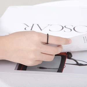 Detailed view of a black twisted rope texture stainless steel ring on a fashion magazine