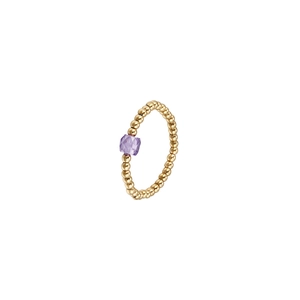 Detailed shot of elastic golden bead ring featuring a central faceted purple zircon stone