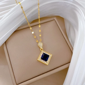 Macro shot of gold necklace featuring blue sapphire pendant in silk jewelry box