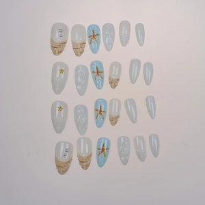 Almond-shaped press-on nails with 3D starfish, pearls, and seashell beach patterns