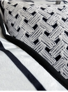Close-up of black and white velvet woven cushion showing detailed knit texture and pattern