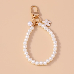 Detailed shot of pearl beaded keychain with gold clasp and elegant white enamel flower charm