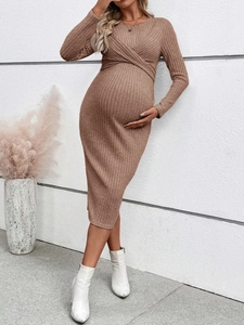 Detail of ribbed knit maternity dress in brown featuring a slim fit and cross knot design
