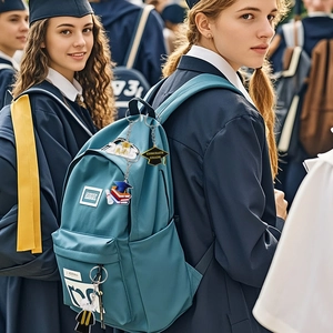 Dettaglio portachiavi laurea 2024 con ciondoli a cappello su uno zaino blu