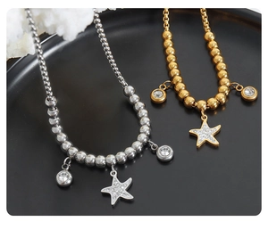Detailed view of gold and silver beaded bracelets with sparkling rhinestone starfish charms