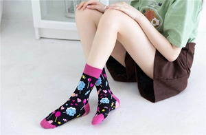 Gros plan de chaussettes en coton avec motifs colorés de bonbons et nuages sur maille noire