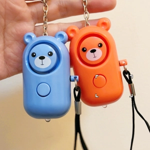 Personal alarm keychain with bear design showing LED light and pull ring trigger