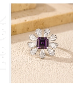 Macro shot of silver ring featuring a violet square gem and teardrop zircons