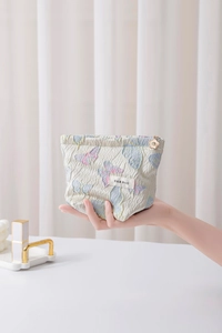 Detailansicht einer Schmetterlings-Jacquard-Kosmetiktasche mit goldenem Blumen-Reißverschluss