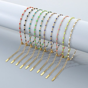Detail showing nine colorful enamel drip oil charms on gold stainless steel anklets