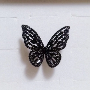 Close-up of black butterfly ring with hollow design and sparkling black gemstones