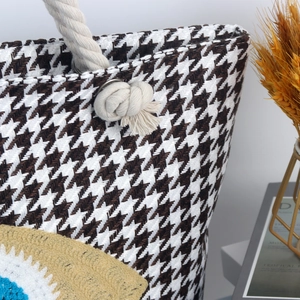 Detail of woven beach bag with black and white houndstooth pattern and cotton rope handle