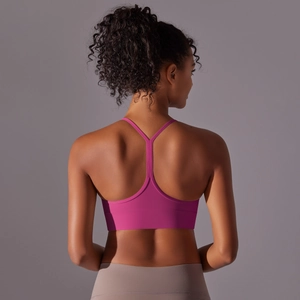Detail view of fuchsia racerback sports bra with Y-shaped straps on female model