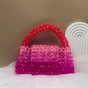 Detail of handmade beaded handbag with purple-red gradient and transparent resin finish