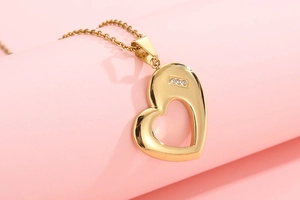 Macro detail of gold-plated stainless steel hollow heart pendant with sparkling crystals