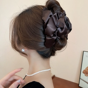 Back view of brown pleated satin scrunchie styled on elegant bun hair accessory