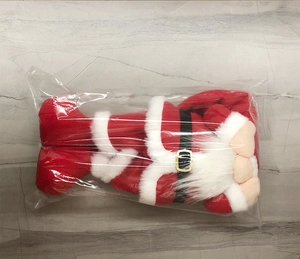 Detail of a Christmas faceless gnome doll in red and white outfit with a black belt