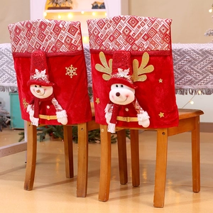 Red Christmas chair covers with snowman and reindeer plush dolls in a cozy dining room