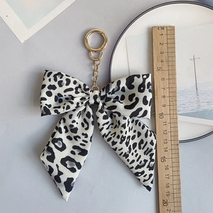 Leopard print fabric bow keychain with golden metal ring and measuring ruler