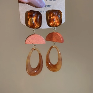 Close-up of vintage geometric resin and wood drop earrings with amber tortoise patterns