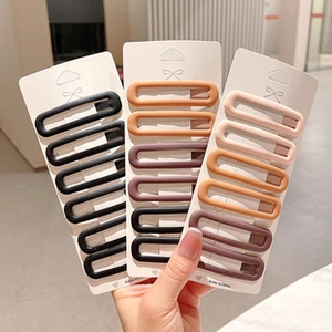 Detail of matte rectangular hair clips in black brown and beige on display cards