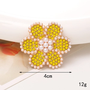 Vue macro d'un accessoire tournesol de 4cm avec strass jaunes et perles pesant 12g