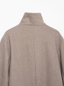 Macro detail of brown wool blend jacket showing high-quality fabric texture and collar stitching