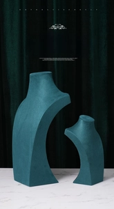 Two peacock green velvet necklace display busts in small and large sizes on marble