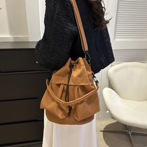 Détail d'un sac seau élégant en nylon camel avec cordon de serrage et accessoires noirs mats