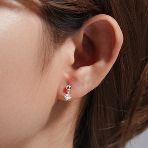 Close-up of a silver cartilage earring featuring a sparkling round zircon stone