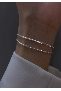 Detail of silver double-layered bracelet with delicate beads and starry shimmer effect