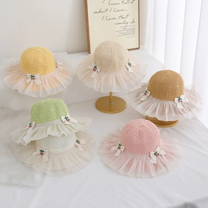 Detail of children's straw sun hats in five pastel colors with lace and cherry accents