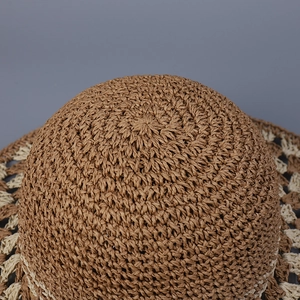 Detail of the brown and beige hand-crocheted paper straw hat crown with spiral weave texture