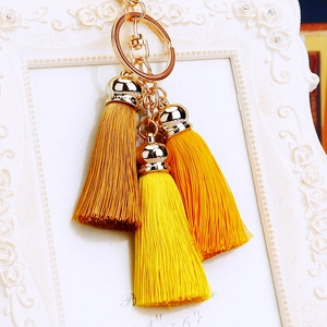 Detailed view of luxury golden silk tassels with metal caps on a stylish keychain