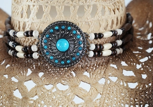 Detail of turquoise stones and vintage silver metal buckle on a woven cowboy hat