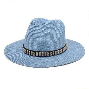 Close-up of blue straw fedora hat featuring black band with silver square metal studs