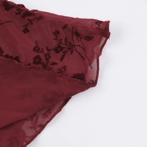 Macro du tissu en maille bordeaux avec motifs floraux floqués sur le haut à manches longues