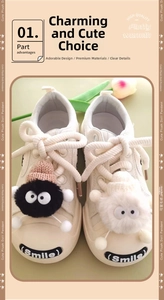 Detail of white canvas shoes decorated with cute black and white plush doll charms on laces