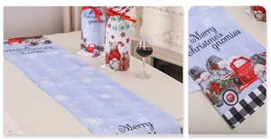 Close-up of linen Christmas table runner and wine covers with festive gnome prints