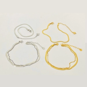 Classic gold and silver flat snake chain anklet set with minimalist pendants on white background