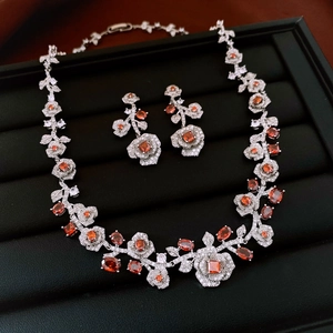 Detail of vintage flower jewelry set with orange gemstones and sparkling zircons
