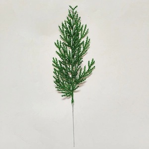 Close-up of artificial green pine branch with shimmering gold glitter for Christmas decor