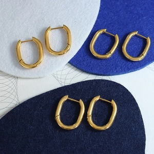 Polished 18K gold-plated U-shaped earrings on colorful geometric felt backgrounds