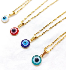 Detail view of gold titanium evil eye necklaces in red, white, blue, and green pendants