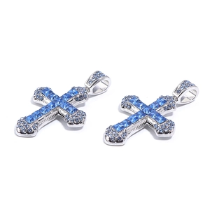 Detailed close-up of silver cross pendants inlaid with blue square and round gemstones