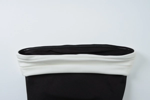 Detail shot of the contrast high-waisted elastic band on black split bodycon dress