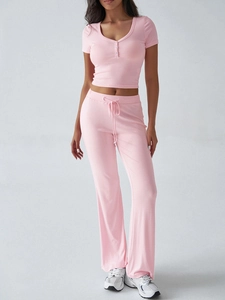 Dettaglio completo del set rosa Y2K in maglia a coste con top a bottoni e pantaloni con lacci